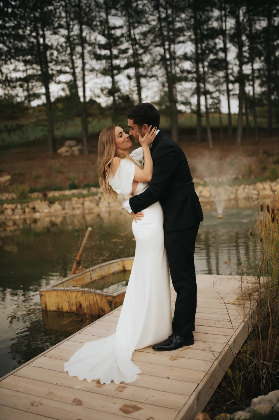 Mariés s'enlaçant sur un ponton en bois au bord de l'eau, mariage en Provence