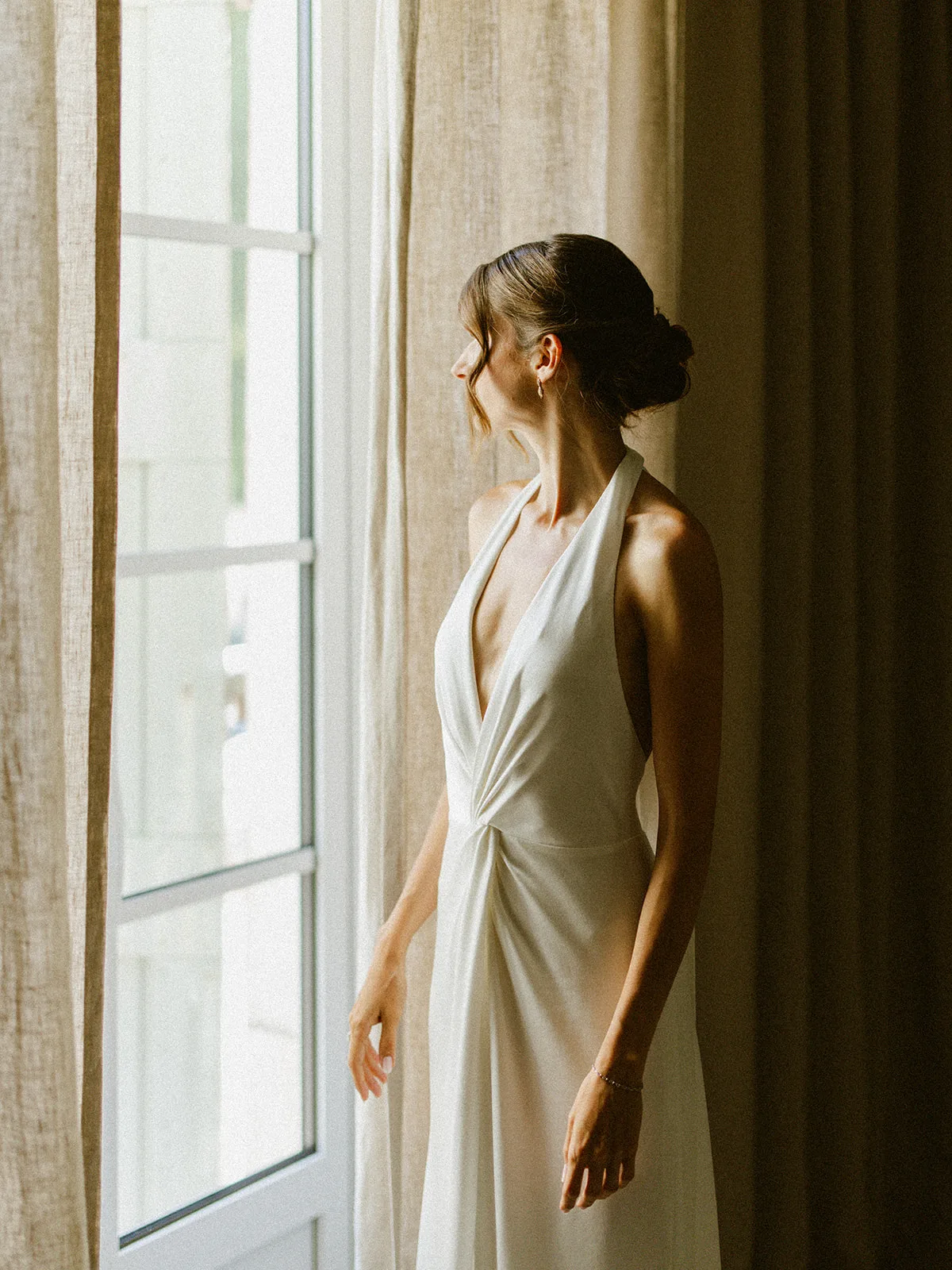 Réka, future mariée de Malo, face à la fenêtre dans la lumière du matin au Château du Griffon