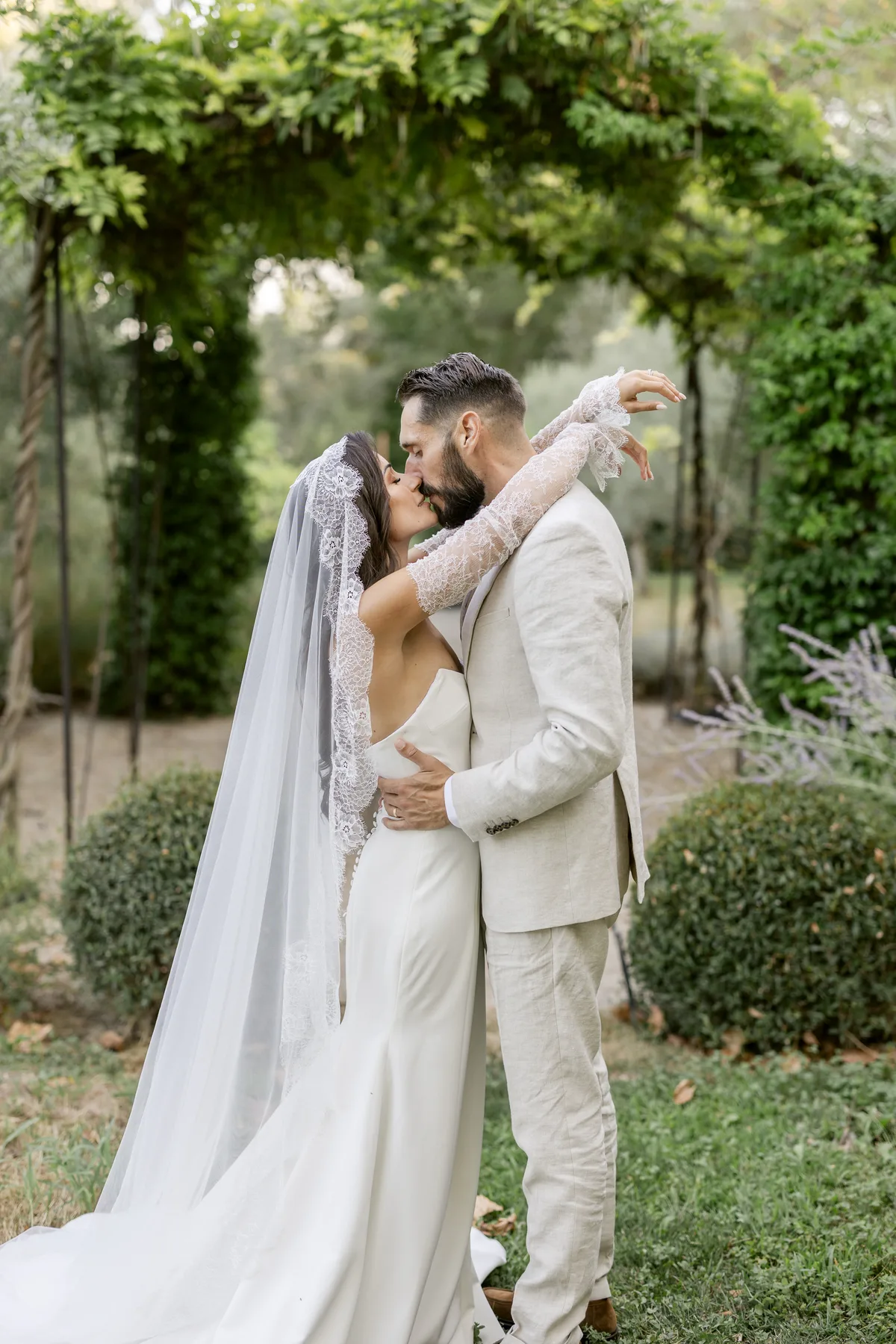 Mariés enlacés sous une tonnelle de glycine lors d'un quiet wedding en Provence
