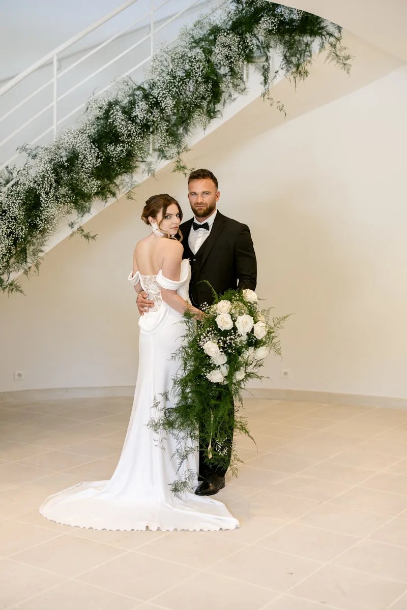 Mariés enlacés sous un escalier fleuri, mariage dans le Luberon
