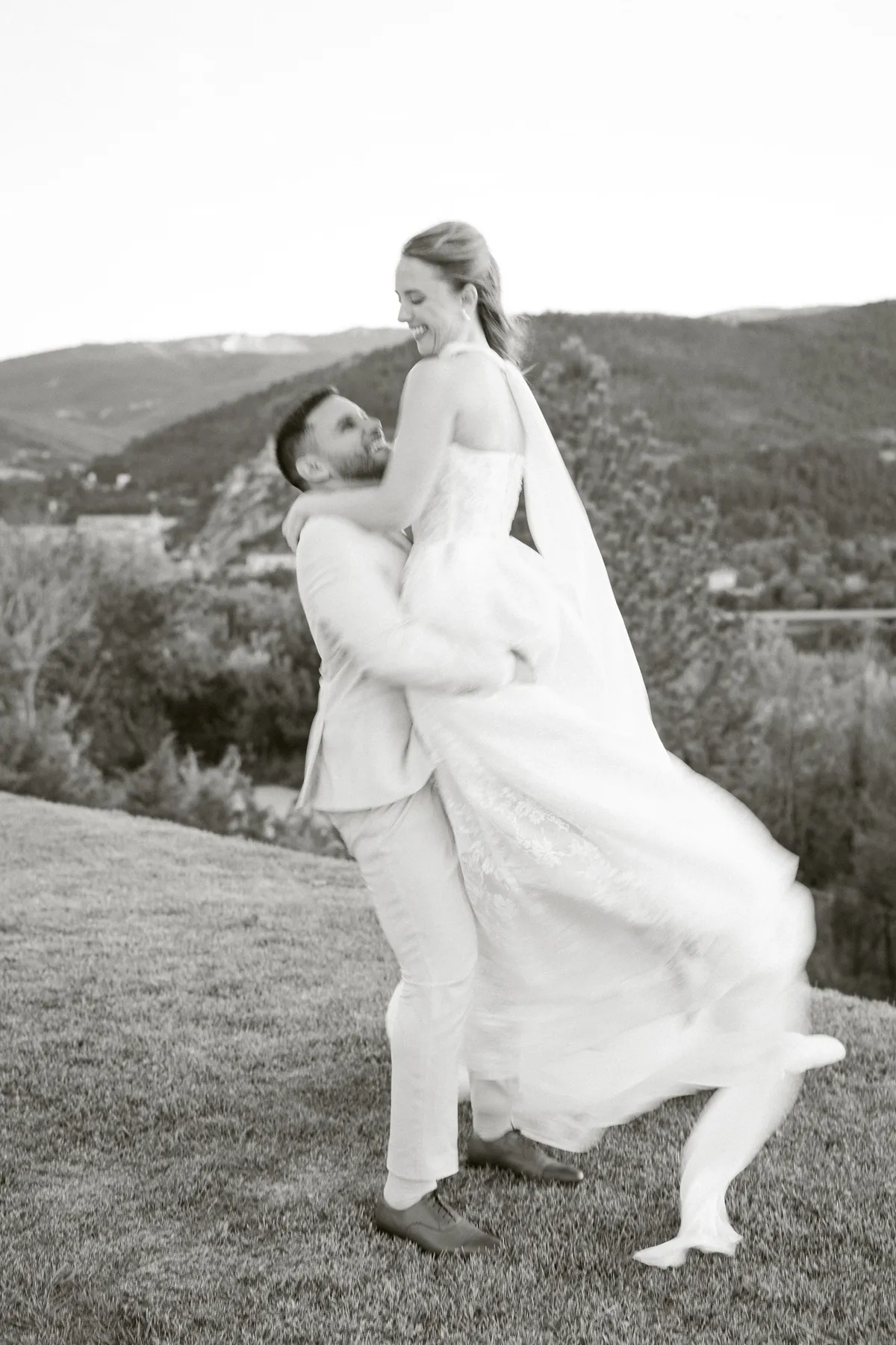 Le marié fait tournoyer la mariée face aux montagnes, mariage au Mas des 5 Fontaines à Sisteron